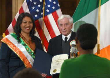 San Francisco, CA - 3 Mart 2023: Mayro London Breed Belediye Binası 'ndaki İrlanda Bayrak Yükseltme Töreninde Emekli Emniyet Müdür Yardımcısı Dermot Philpot' a sertifika sunar.