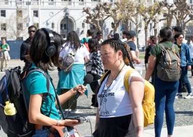 San Francisco, CA - 21 Nisan 2023: KPFA muhabiri Belediye Binası önündeki İklim Protesto Yürüyüşünde Gençlik Gençlik Gençlik Gençliğine Karşı Röportajı. 