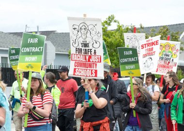 Oakland, CA - 8 Mayıs 2023: Yüzlerce öğretmen, veli ve destekçi Oakland 'ın dağlık kesiminde düzenlenen bir grev mitinginde yürüyor.