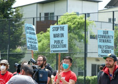 Oakland, CA - 8 Mayıs 2023: Yüzlerce öğretmen, veli ve destekçi Oakland 'ın dağlık kesiminde düzenlenen bir grev mitinginde yürüyor.