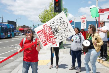 Oakland, CA - 9 Mayıs 2023: Öğretmenler, Aileler ve Destekçiler, 73. Cadde ile Uluslararası Bulvar 'ın köşesindeki öğretmen grevi gününde ellerinde pankart ve pankart tutuyorlar