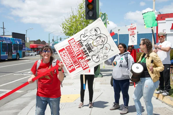 Oakland, CA - 9 Mayıs 2023: Öğretmenler, Aileler ve Destekçiler, 73. Cadde ile Uluslararası Bulvar 'ın köşesindeki öğretmen grevi gününde ellerinde pankart ve pankart tutuyorlar
