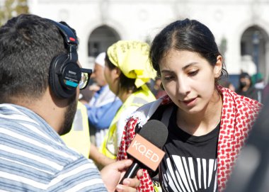 San Francisco, CA - Nov 4, 2023: News outlet KQED interviewing participants at the Palestine War Protest rally at Civic Center prior to their March down Market Street clipart