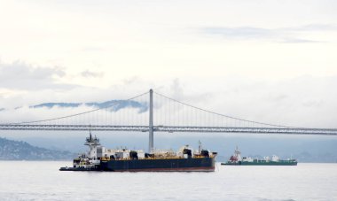 San Francisco, CA - 20 Aralık 2023: Römorkör kargo gemisinin San Francisco Körfezi 'nden geçmesine yardım ediyor..