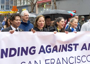 San Francisco, CA - 03 Mart 2024: Politikacılar ve tanımlanamayan katılımcılar Pazar Caddesi 'ndeki Anti-Semitizm karşıtı bir yürüyüşe katıldılar. Yağmurda yürürken.