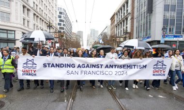 San Francisco, CA - 03 Mart 2024: Politikacılar ve tanımlanamayan katılımcılar Pazar Caddesi 'ndeki Anti-Semitizm karşıtı bir yürüyüşe katıldılar. Yağmurda yürürken.