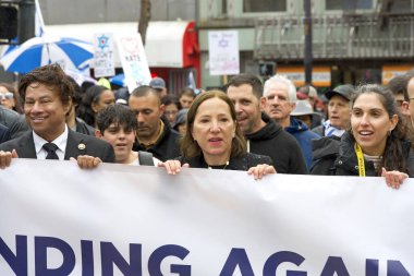 San Francisco, CA - 03 Mart 2024: Politikacılar ve tanımlanamayan katılımcılar Pazar Caddesi 'ndeki Anti-Semitizm karşıtı bir yürüyüşe katıldılar. Yağmurda yürürken.