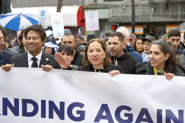 San Francisco, CA - 03 Mart 2024: Politikacılar ve tanımlanamayan katılımcılar Pazar Caddesi 'ndeki Anti-Semitizm karşıtı bir yürüyüşe katıldılar. Yağmurda yürürken.