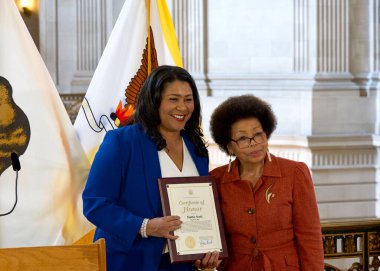 San Francisco, CA - 19 Mart 2024: Belediye Başkanı London Breed, Belediye Binası 'nda düzenlenen Kadın Tarihi Ayı Seremonisinde Mattie Scott' a onur belgesi sunuyor.