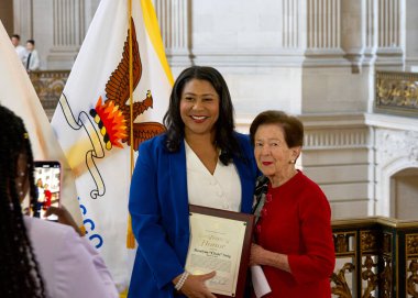 San Francisco, CA - 19 Mart 2024: Belediye Başkanı London Breed, Roselyne Cissie 'ye onur belgesini sunuyor..