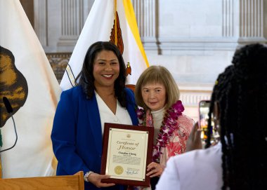 San Francisco, CA - 19 Mart 2024: Belediye Başkanı London Breed, Belediye Binası 'nda düzenlenen Kadın Tarihi Ayı Töreni' nde Claudine Cheng 'e onur belgesi sunuyor.