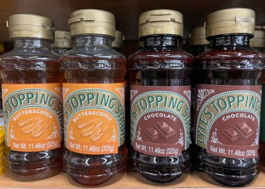 Oakland, CA - 1 Temmuz 2022: Lyle 's Topping Syrup şişeleriyle market rafı. Karamela ve çikolata aromalı..