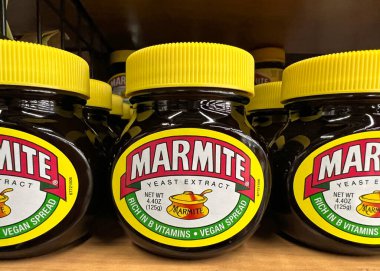 Oakland, CA - 1 Temmuz 2022 Marmite marka maya özütüyle dolu market rafı. Bira demlemenin bir yan ürünü. Kahvaltıda ve öğle yemeğinde tost yerken her zaman keyif alırdı.