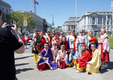 San Francisco, CA - 21 Nisan 2024: Geleneksel Kiraz Çiçeği Geçit Töreni 'ne katılanlar geçit töreninden önce Belediye Binası önünde grup fotoğrafları için poz veriyorlar