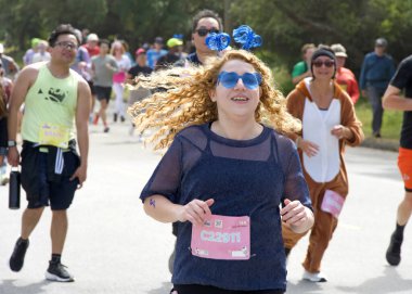 San Francisco, CA - 19 Mayıs 2024: Geleneksel Bay to Breakers yarışına katılanlar Golden Gate parkından geçecekler. Bay to Breakers, eğlenceli kostümler giyen birçok katılımcısıyla ünlüdür..
