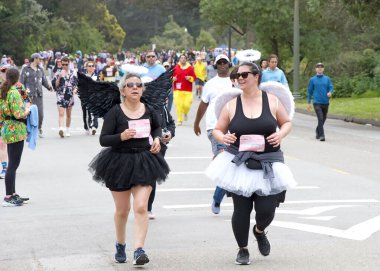 San Francisco, CA - 19 Mayıs 2024: Geleneksel Bay to Breakers yarışına katılanlar Golden Gate parkından geçecekler. Bay to Breakers, eğlenceli kostümler giyen birçok katılımcısıyla ünlüdür..