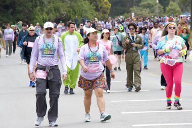 San Francisco, CA - 19 Mayıs 2024: Geleneksel Bay to Breakers yarışına katılanlar Golden Gate parkından geçecekler. Bay to Breakers, eğlenceli kostümler giyen birçok katılımcısıyla ünlüdür..