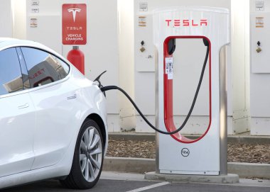 Coalinga, CA - 29 Mayıs 2024: Orta Kaliforniya 'daki Harris Ranch Resort' taki Tesla Superşarj istasyonunda araba şarj ediliyor.