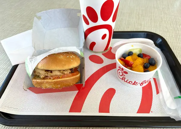 stock image Redwood City, CA - May 14, 2024: Close up on Grilled Chicken Sandwich and fruit cup with soda cup in background on a serving tray at Chick-fil-a fast food restaurant.