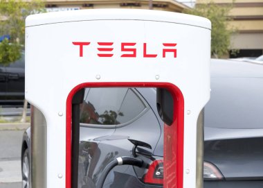 Alameda, CA - 25 Mayıs 2024: EV 'ye bağlı Tesla Superşarj istasyonuna yakın çekim. Tesla Superşarj istasyonları, Tesla arabalarının bir saat içinde kanalda hızlı şarj edilmesine izin veriyor..