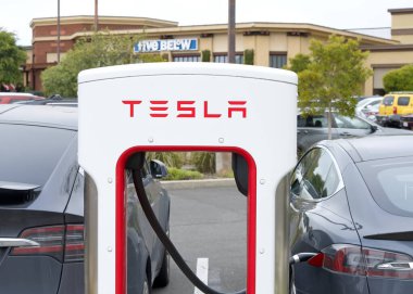 Alameda, CA - 25 Mayıs 2024: EV 'ye bağlı Tesla Superşarj istasyonuna yakın çekim. Tesla Superşarj istasyonları, Tesla arabalarının bir saat içinde kanalda hızlı şarj edilmesine izin veriyor..
