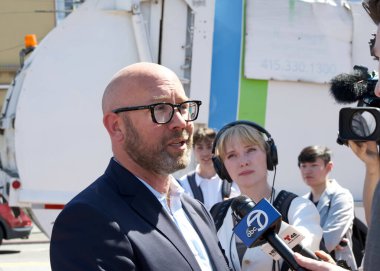 San Francisco, CA - Sept 13, 2024:  Supervisor Rafael Mandelman speaking with reporters at the Gilbert Baker Rainbow Landmarking Signing flag raising event. clipart