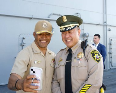 San Francisco, CA - 8 Ekim 2024: Şerif Paul Miyamoto, USS Trablus Limanı 'ndaki 43. Filo Açılış Töreni' nde donanma ekibiyle fotoğraf çekiyor.