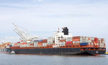 Oakland, CA - 1 Kasım 2024: Liberya kargo gemisi UTE Oakland limanına birden fazla römorkörle giriş yapıyor..