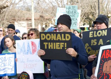 Oakland, CA - 17 Şubat 2025: Başkanlar Günü 'nde Meyve Valesi Bart' tan Merritt Gölü 'ne yürüyüş ve yürüyüş yapan kimliği belirsiz katılımcılar. Merritt Gölü Rallisi 'nde tabelalar duruyor..