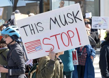 Berkeley, CA - 1 Mart 2025: Protestocular Tesla galerisinin önündeki trafiği engelleyen işaretler taşıyorlar. Misk 'i kınamak ve Capitol Hill' deki son eylemlerinin sonucu olarak boykot çağrısında bulunmak.