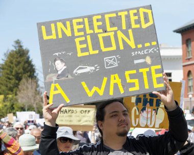 Alameda, CA - 5 Nisan 2025: Bir el yapımı, kaldırma, geri çevirme, protesto mitinginin tanımlanamayan katılımcıları belediye binası önünde toplanıyor. Mevcut yönetimi protesto etmek.