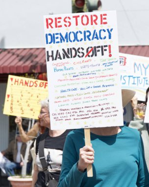 Alameda, CA - 5 Nisan 2025: Bir el yapımı, kaldırma, geri çevirme, protesto mitinginin tanımlanamayan katılımcıları belediye binası önünde toplanıyor. Mevcut yönetimi protesto etmek.