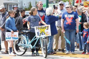 Alameda, CA - 14 Haziran 2025: Kimliği belirsiz kişiler, Kings 'e Hayır Yürüyüşü yürüyüşü' nde şehir sokaklarında yürüyor. Trafik kurallarına uyarak kaldırımlarda yürüyor ve yaya geçitlerinde bekliyor.