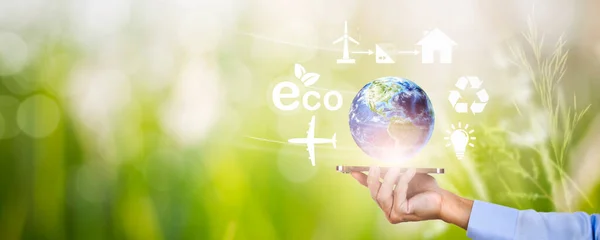 Ecology World Earth Day Concept, Hands holding smartphone with World with ecology icons on green nature background, planet Earth, Save clean planet,Save world and environment Eco, banner, copy space.