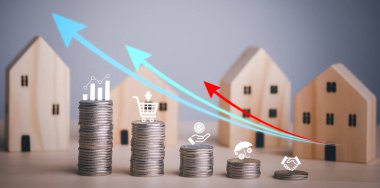 Paralar ahşap ev ve ok işinin önüne istiflenir, para tasarrufu konsepti, emlak yatırımı, ev kredisi, ters ipotek, altın sikkeler para yığını büyümesi, para biriktirme ev için gelecek istifleme 