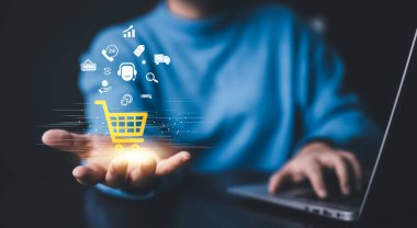 İş adamı online alışveriş kavramına sahip bir dizüstü bilgisayar kullanıyor, çevrimiçi alışveriş arabasının sanal arayüzüne sahip pazar sitesi ağın bir parçası, alışveriş arabası seçen online alışveriş işi.