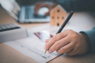 ABD Gelir İdaresi 1040 formu veya ABD Bireysel Gelir Vergisi Konsepti, muhasebeci elinde veri muhasebe belgeleri ve dizüstü bilgisayarla hesap makinesi işi yapan bir kalem tutuyor, 2023 yılında vergi ödüyor, yeni yıl 2023 vergi kavramı.