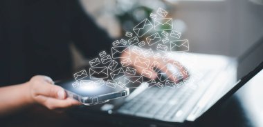 İletişim simgeleri, harf simgesi, e- posta simgeleri ve haber e- postalarına sahip akıllı telefonları tutan ve kişisel bilgilerinizi ya da spam postalarınızı koruyan iş adamları, Müşteri hizmetleri çağrı merkezi irtibat bilgilerinizi.