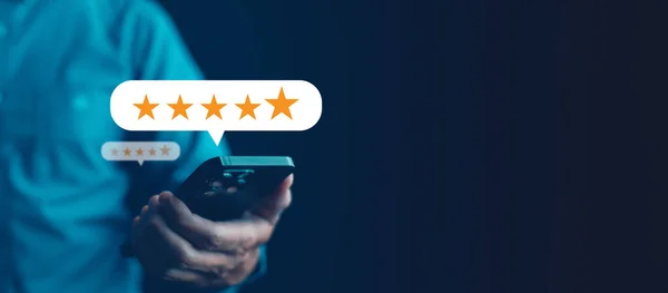Business people hand using smartphone with popup five star icon for feedback review satisfaction service, Customer service experience and business satisfaction survey.