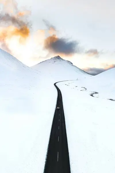 Beyaz kış manzarasında uzun siyah yol