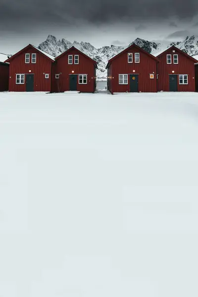 Norveç 'in Sakrisoy adasının karlı sahillerinde kırmızı kulübeler.
