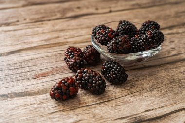 A Blackberries on a rustic wooden board. Horizontal orientation, space for text.