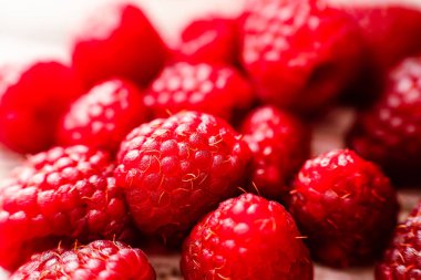 Close up of some isolated raspberries. Horizontal orientation, space for text. Large detail of the fruits