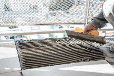 Çentikli bir mala kullanarak beton döşemeye beton döşeyen duvarcı. Bir inşaatta çalışıyorum. İş kavramı, ticaret.