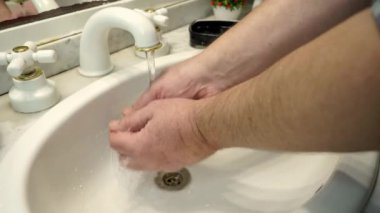 Adam ellerini lavaboda sabunla yıkıyor. 4k,