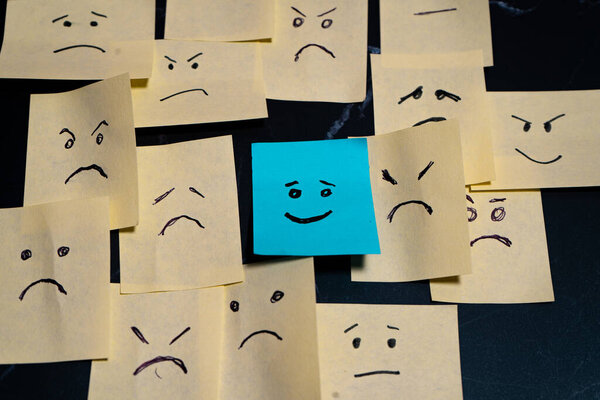 Концептуальный образ, созданный с помощью стикеров, символизирующих надежду или радость, окруженный печалью, гневом и безнадежностью.