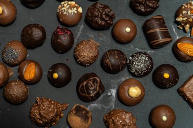 Değişik aromalı çikolatalı bonbonlar siyah bir mermer üzerinde.