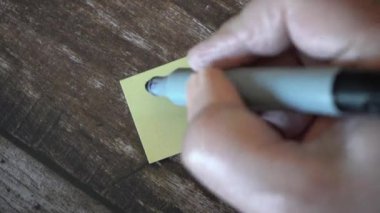 Kağıtlara ya da post-it 'lere Hello yazan bir adamın eli.