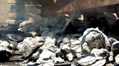 Izgaranın altında ızgara için dumanlı kömür közleri.