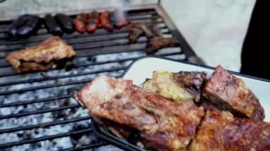 Barbeküden arta kalan etleri temizleyen bir adam..